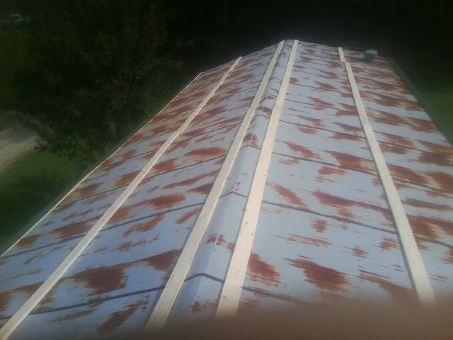 Rusted metal roof panels with new wood purlins before replacement — Storm Damage Roof Repair in Swartz Creek by Roofing Brothers