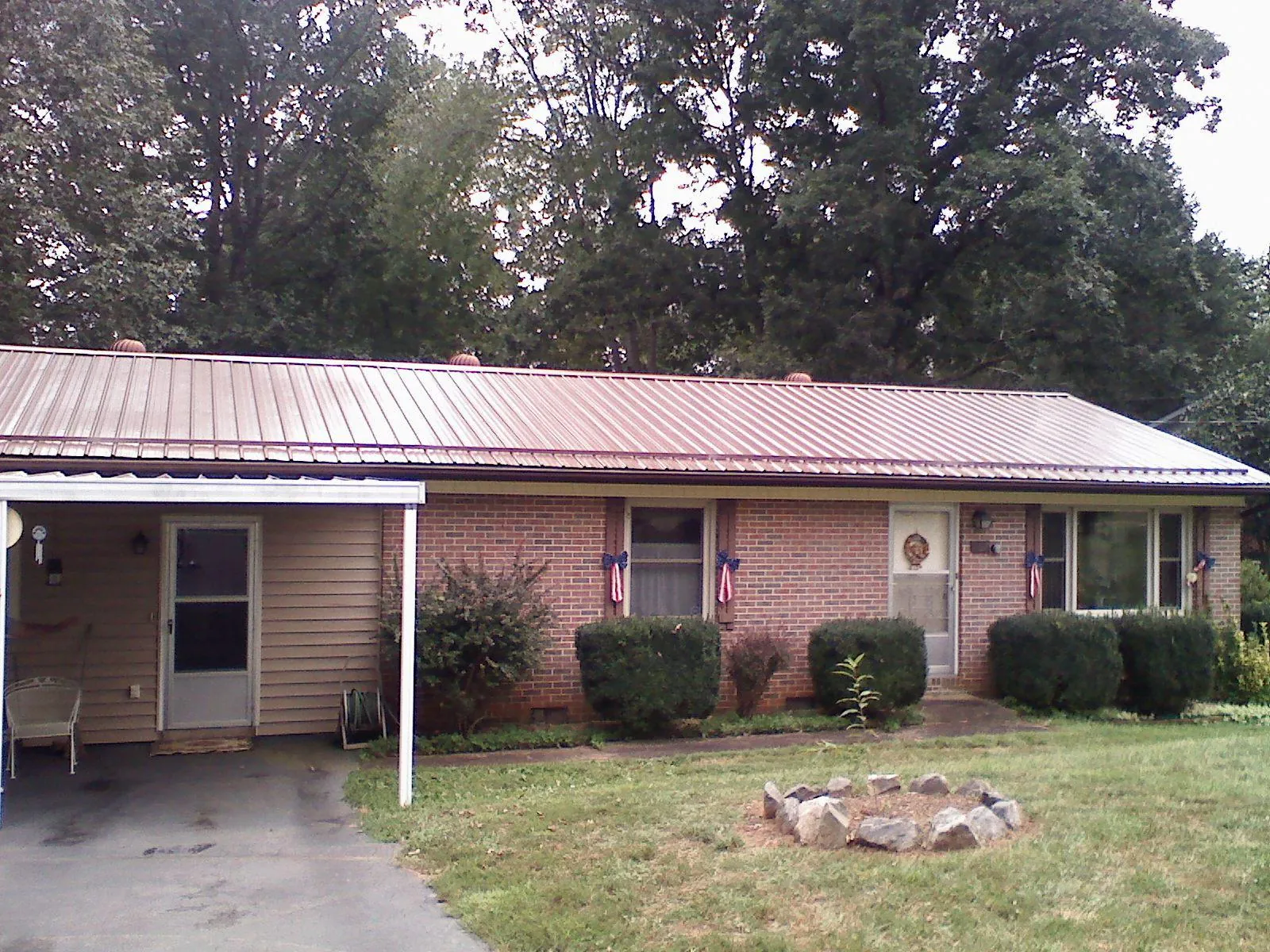 Bronze metal roof and carport on a brick ranch home — Roof Repair work by our crew in Swartz Creek