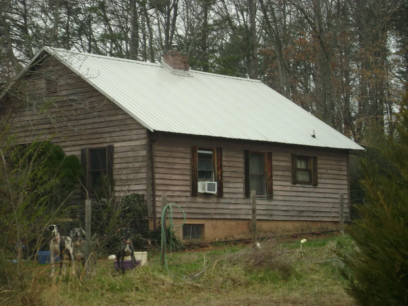 White metal roof on an old wood sided farmhouse, from a Metal Roof Installation job in Swartz Creek